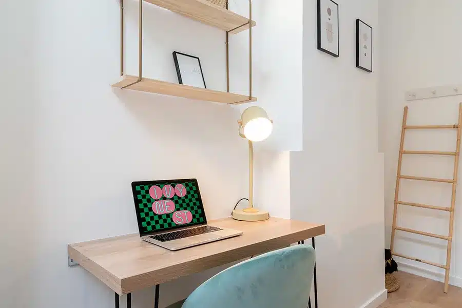 Bureau en bois sous étagères suspendues, ordinateur portable et lampe — Maison Colbert, coliving IvyNest à Lille