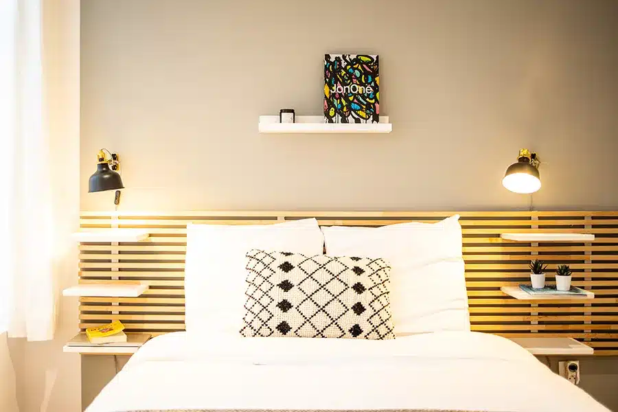 Chambre avec tête de lit en lattes de bois et deux liseuses noires — Maison Gambetta, coliving IvyNest à Lille Wazemmes