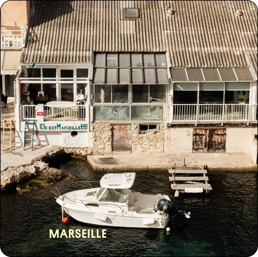 Vieux port de Marseille avec bateau à moteur et cabanons sur l'eau — coliving IvyNest à Marseille