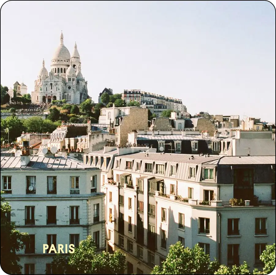 Toits parisiens et basilique du Sacré-Cœur de Montmartre sous un ciel bleu — coliving IvyNest à Paris
