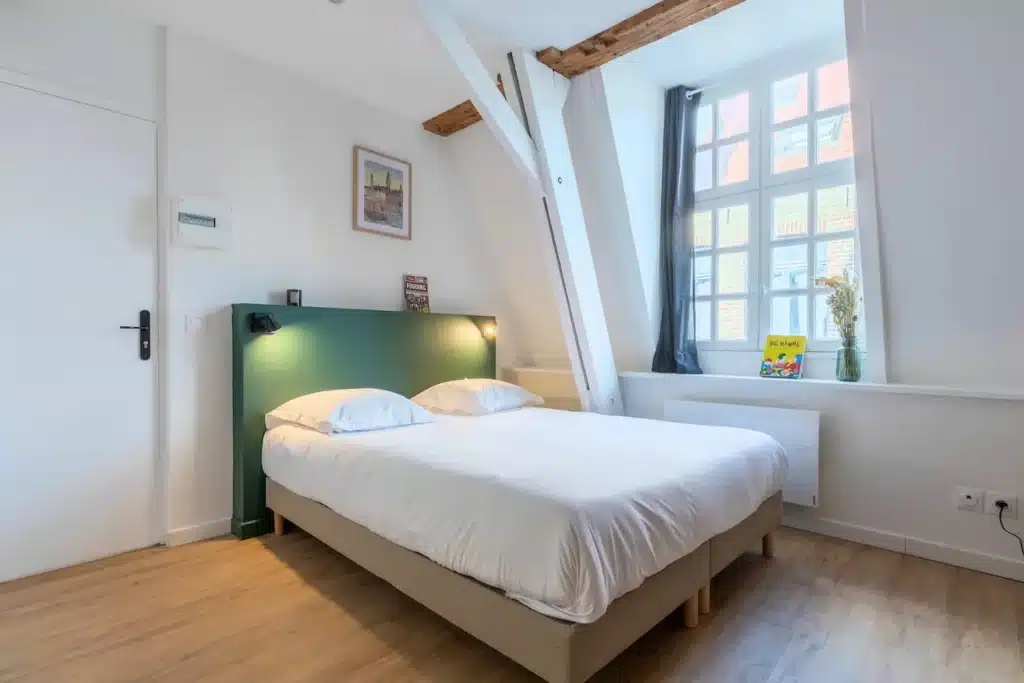 Chambre avec lit double, tête de lit verte et poutres apparentes — Maison 3 Mollettes, coliving IvyNest dans le Vieux-Lille