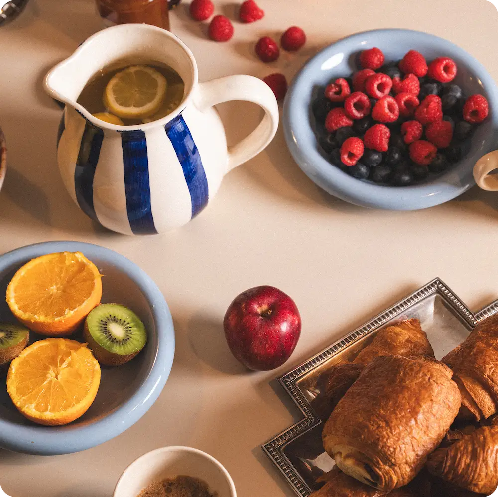 Petit-déjeuner partagé avec fruits et viennoiseries dans un coliving IvyNest