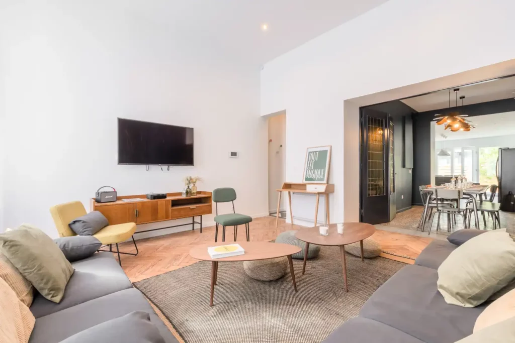 Salon spacieux avec canapés gris, fauteuil jaune et salle à manger — Maison Caumartin, coliving IvyNest à Lille Centre
