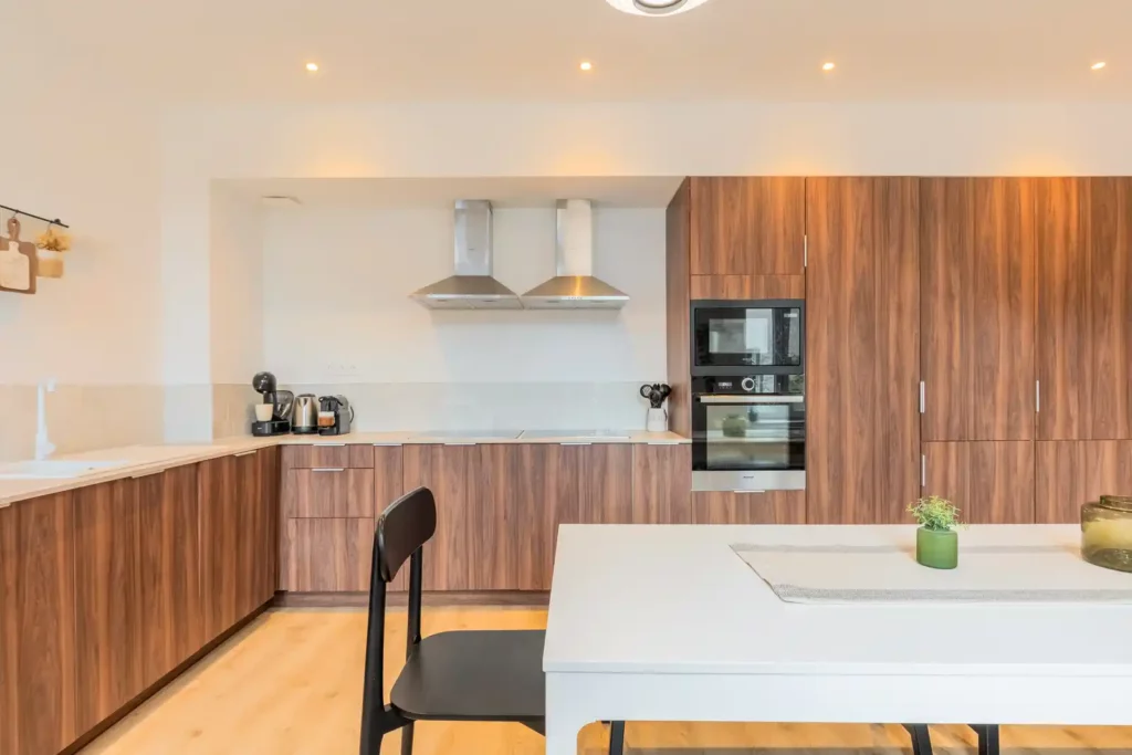 Cuisine avec fours encastrés, hottes et plan de travail en bois — Maison Centre, coliving IvyNest à La Madeleine
