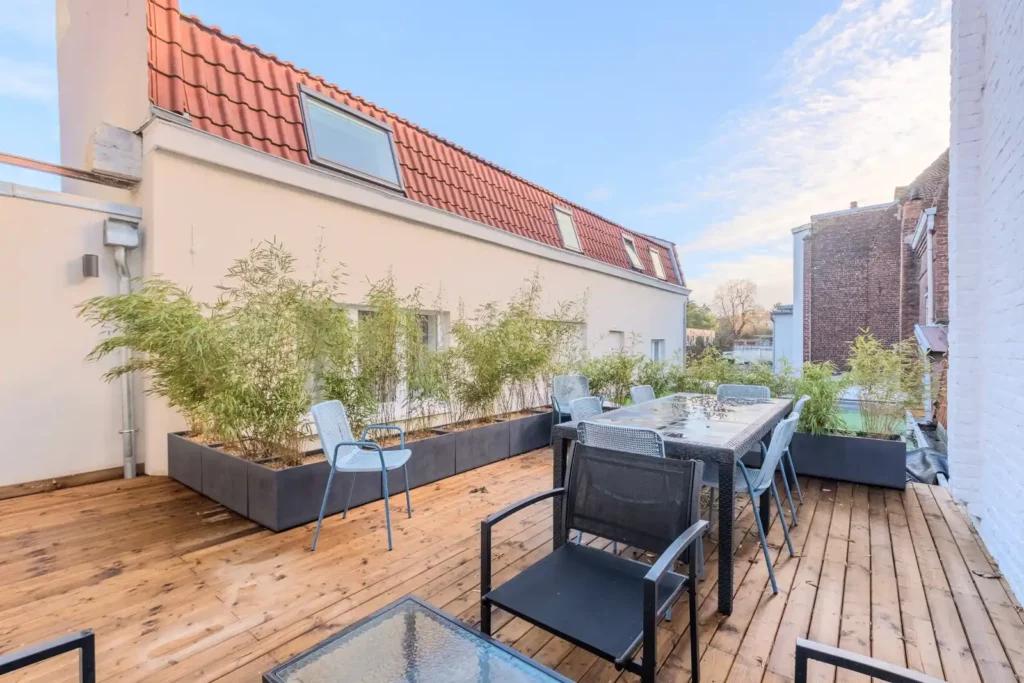 Terrasse en bois avec bacs de bambous et salon de jardin — Maison Centre, coliving IvyNest à La Madeleine