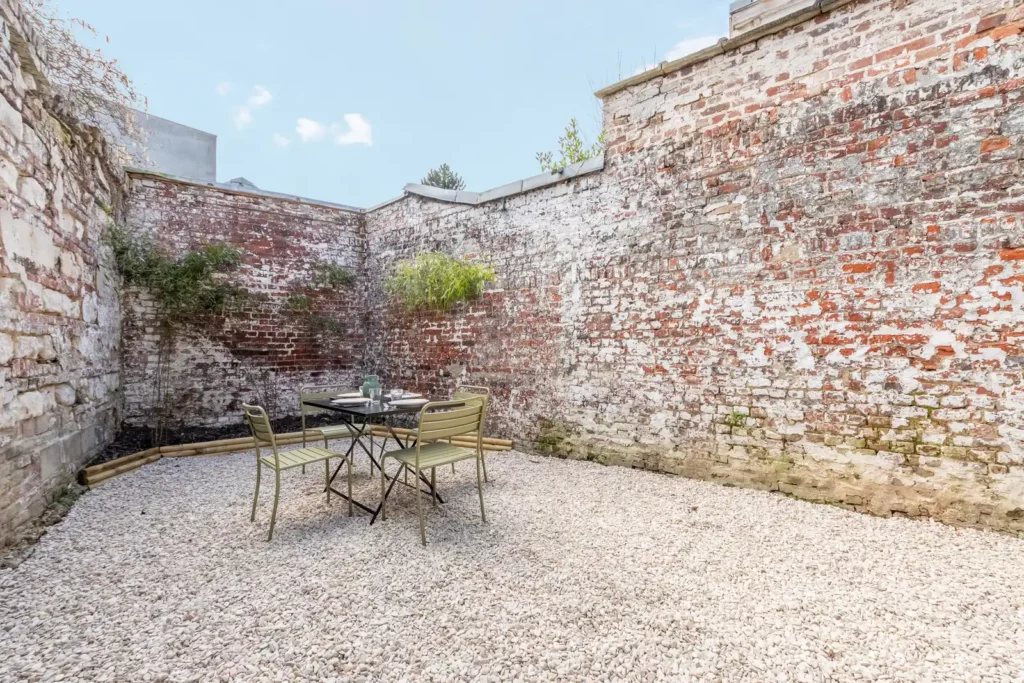 Jardin clos entouré de murs en briques et pierres — Maison Saint-Maurice, coliving IvyNest à Lille Saint-Maurice