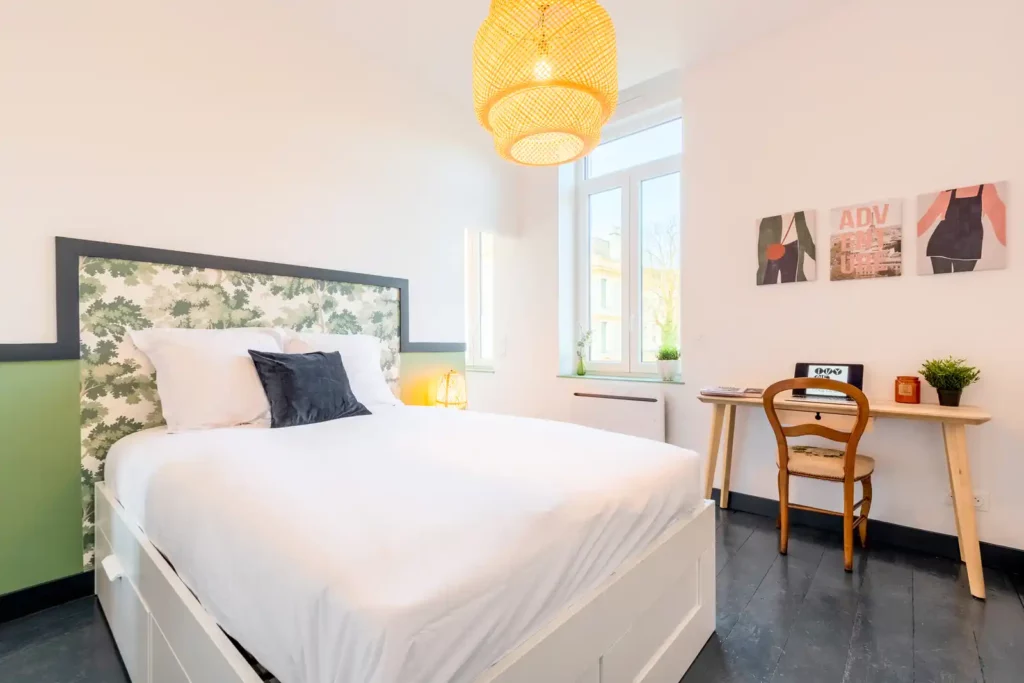 Chambre avec tête de lit végétale, bureau en bois et affiches — Maison Saint-Maurice, coliving IvyNest à Lille Saint-Maurice