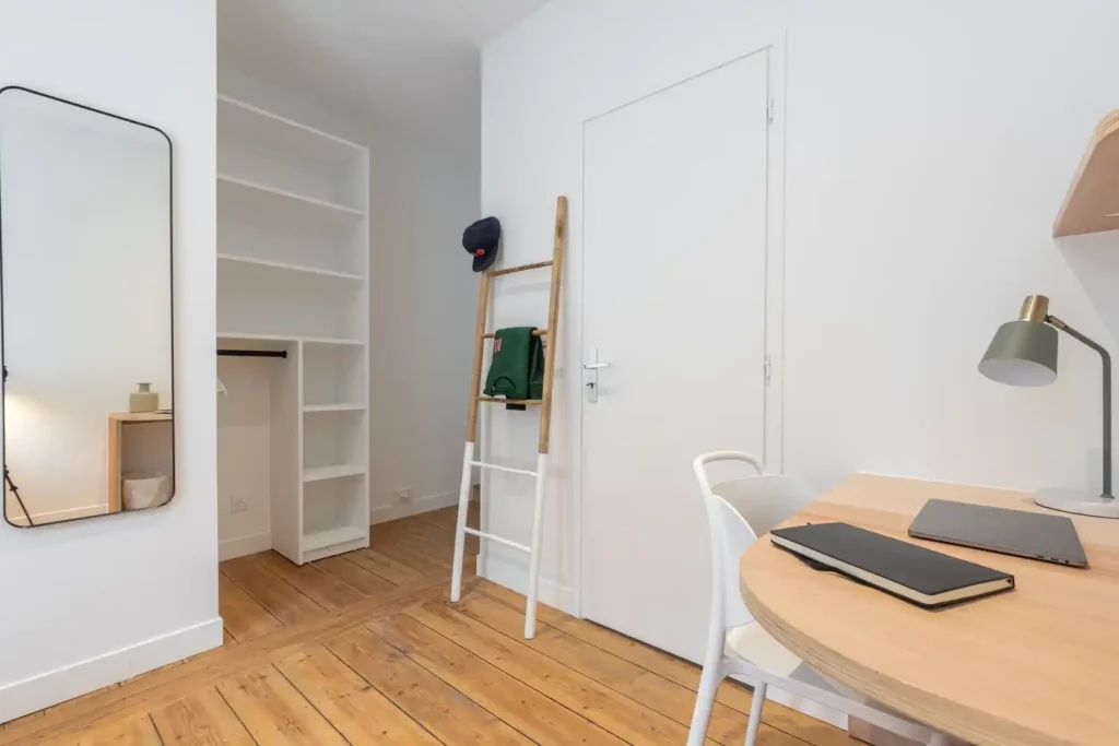 Chambre avec bureau rond, dressing ouvert et grand miroir — Maison Sainte-Catherine, coliving IvyNest dans le Vieux-Lille