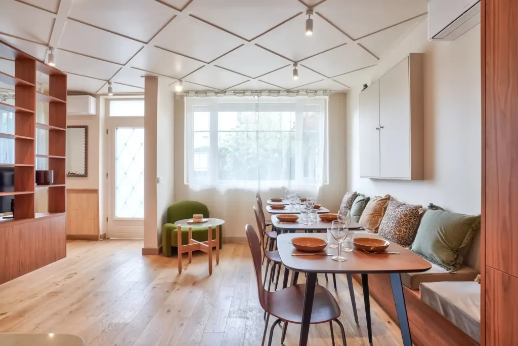 Salle à manger avec bibliothèque en bois et fenêtre sur la rue — Maison Issy-les-Moulineaux, coliving IvyNest (Île-de-France)
