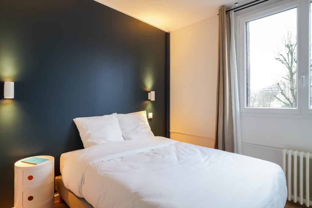 Chambre avec mur bleu foncé du coliving Paris Kremlin-Bicêtre