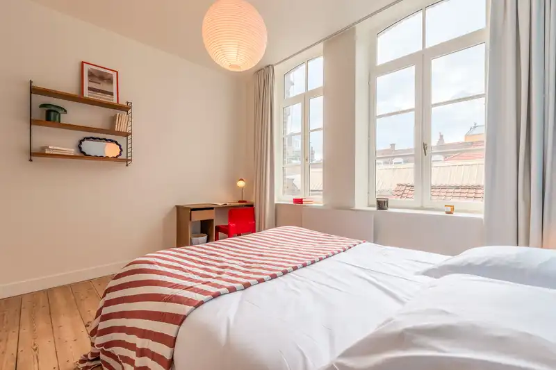 Chambre claire avec lit double à plaid rayé rouge et petit bureau — Maison Rousseau, coliving IvyNest dans le Vieux-Lille