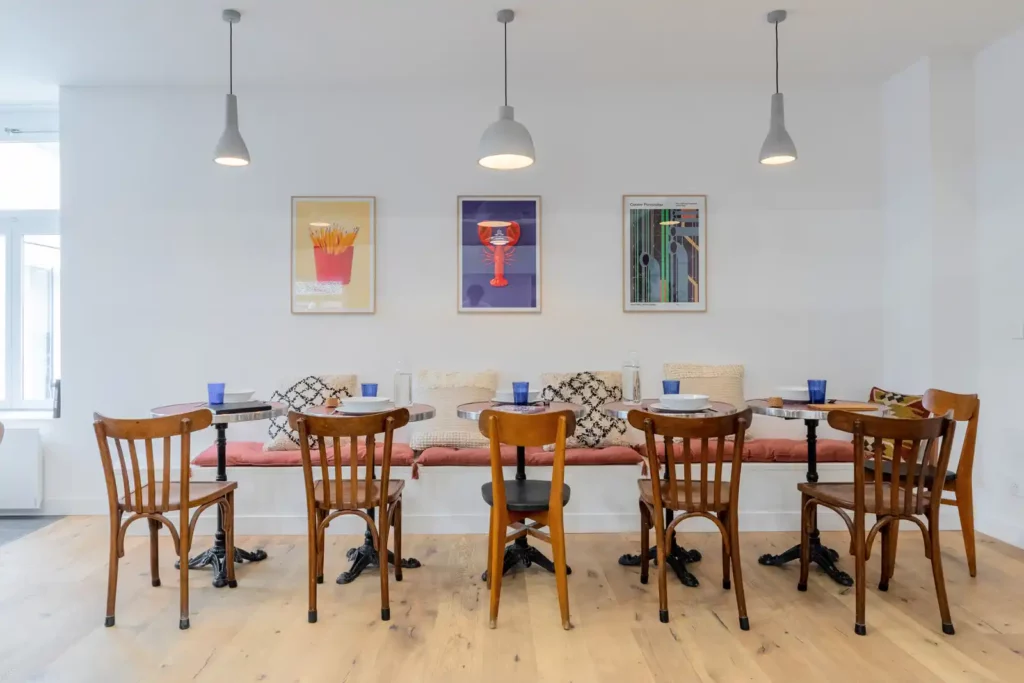 Table de repas avec chaises bistrot et affiches colorées — Maison Sainte-Catherine, coliving IvyNest dans le Vieux-Lille