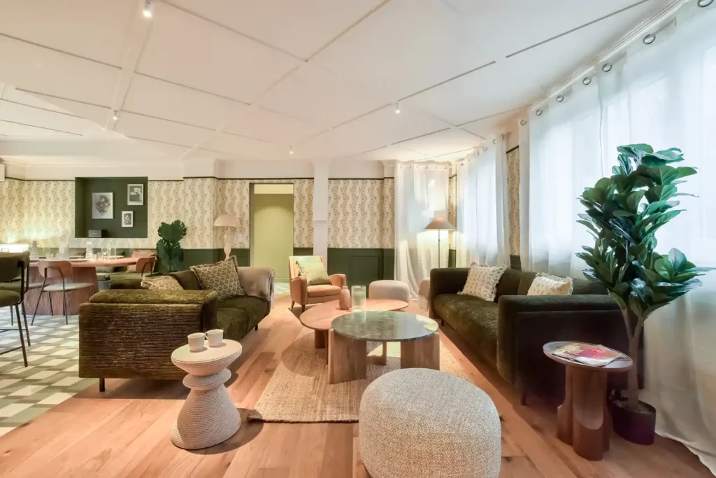 Grand séjour avec canapés verts, tables basses et pouf bouclé — Maison Fontenay-aux-Roses, coliving IvyNest (Île-de-France)