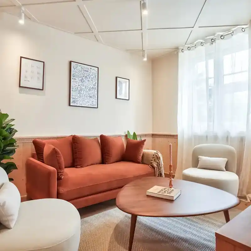 Salon avec canapé terracotta et fauteuils bouclés — Maison Issy-les-Moulineaux, coliving IvyNest à Issy