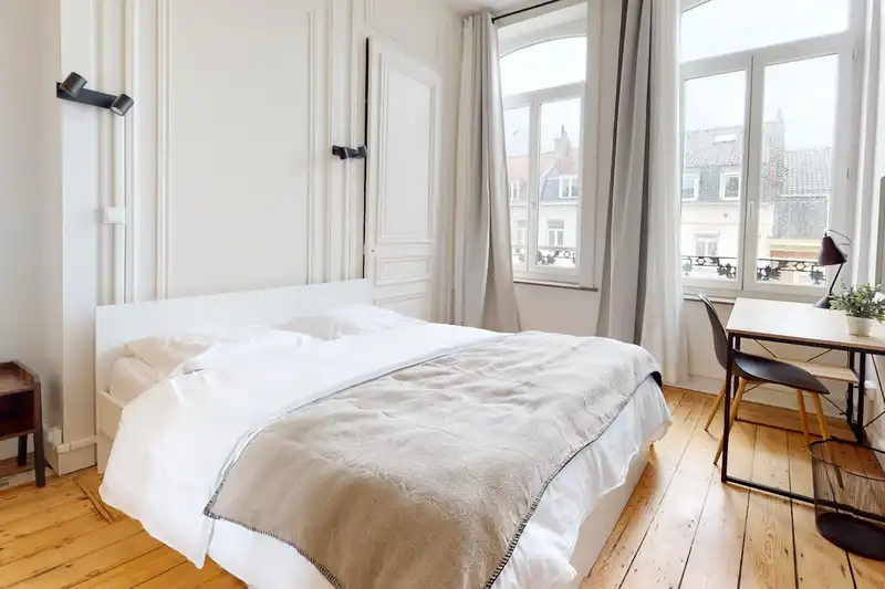 Chambre avec lit double, bureau et fenêtres sur parquet ancien — Maison 251 Solférino, coliving IvyNest à Lille République