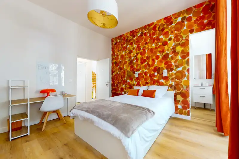 Chambre avec lit double, papier peint orange et bureau blanc — Maison 39 Bigo-Danel, coliving IvyNest à Lille Vauban