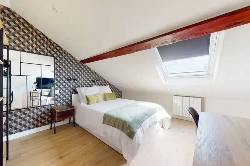 Chambre mansardée avec poutre apparente, lit double et bureau — Maison Artois, coliving IvyNest à Lille JB Lebas