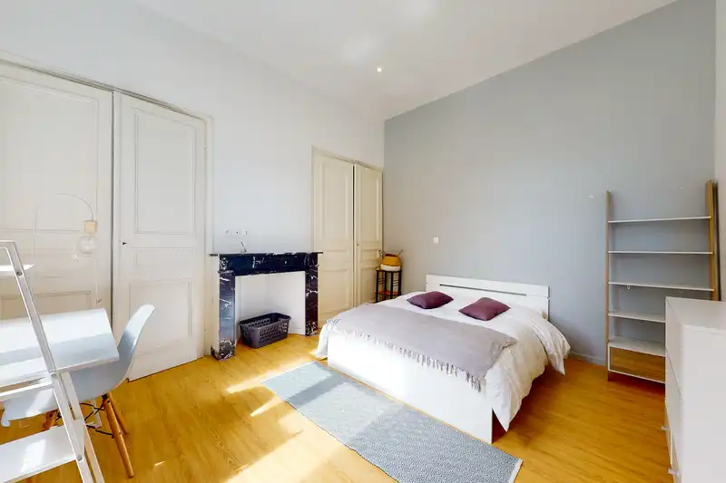 Chambre avec placards blancs, lit double à plaid gris et tapis bleu — Maison 37 Bigo-Danel, coliving IvyNest à Lille Vauban