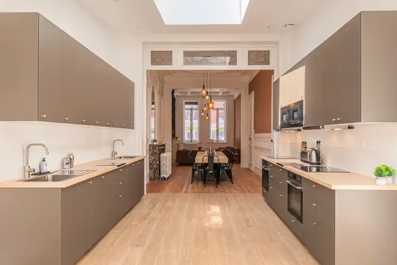 Cuisine équipée taupe et blanche sous verrière, vue sur la salle à manger — Maison Douai, coliving IvyNest à Lille JB Lebas