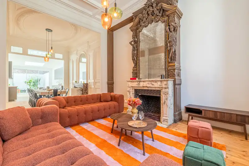 Salon avec canapés cuir rouille, tapis orange et cheminée en marbre — Maison Douai, coliving IvyNest à Lille JB Lebas