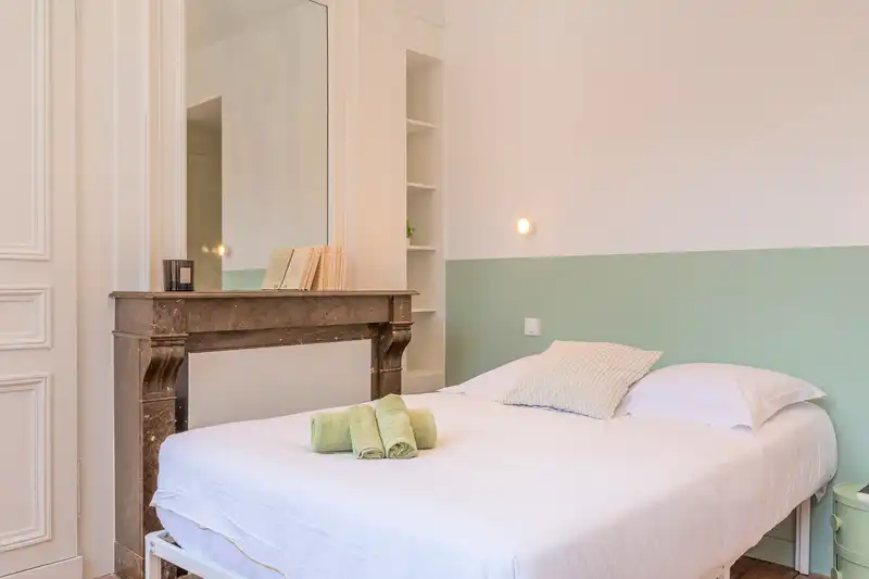 Chambre avec lit double, cheminée en marbre et mur vert d'eau — Maison Douai, coliving IvyNest à Lille JB Lebas