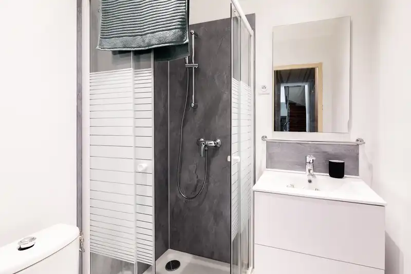 Salle de bain avec douche en pierre grise et parois striées — Maison Jeanne d'Arc, coliving IvyNest à Lille République