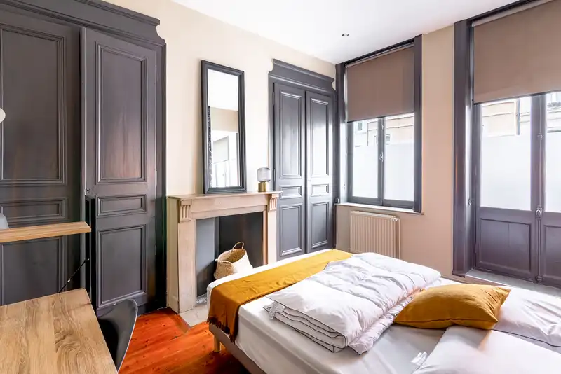 Chambre aux boiseries grises, lit double et cheminée — Maison Jeanne d'Arc, coliving IvyNest à Lille République