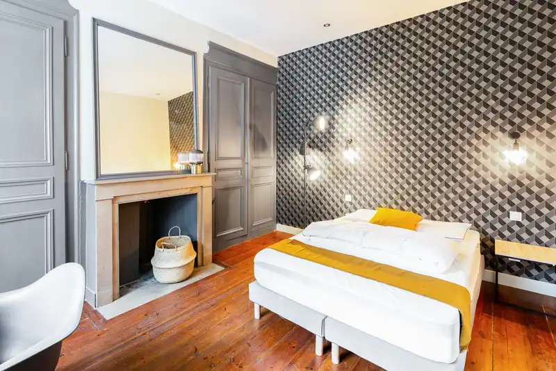 Chambre avec lit double, papier peint géométrique et cheminée — Maison Jeanne d'Arc, coliving IvyNest à Lille République