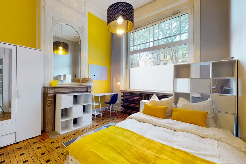 Chambre avec lit double, plaid jaune et parquet à motifs — Maison 37 Bigo-Danel, coliving IvyNest à Lille Vauban