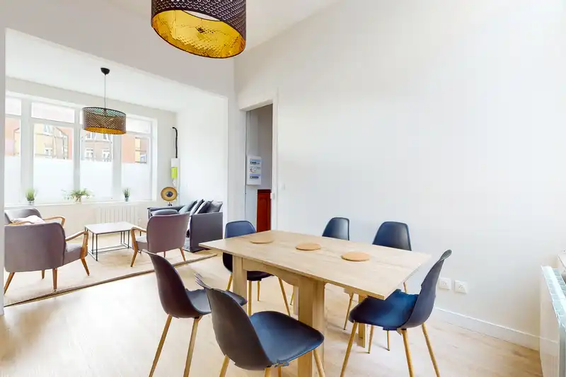 Salle à manger avec table en bois et chaises noires — Maison Artois, coliving IvyNest à Lille JB Lebas