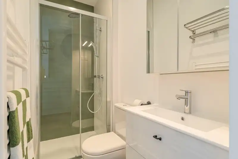 Salle de bain avec douche vitrée, sèche-serviettes et toilettes — Maison Douai, coliving IvyNest à Lille JB Lebas