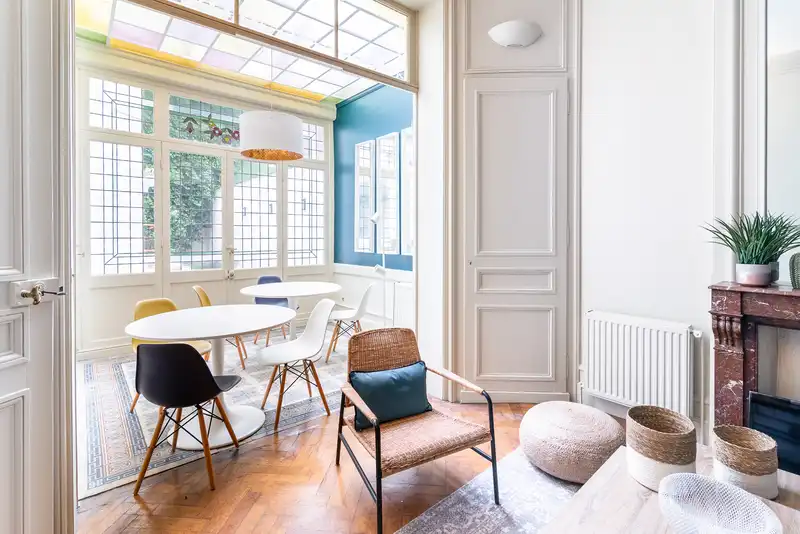 Salle à manger sous verrière avec table ronde et mur bleu — Maison Jeanne d'Arc, coliving IvyNest à Lille République