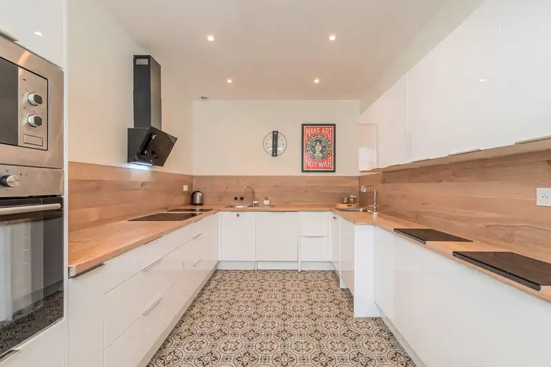 Cuisine blanche en U avec plan de travail en bois et sol en carreaux — Maison 67 Roland, coliving IvyNest à Lille Vauban