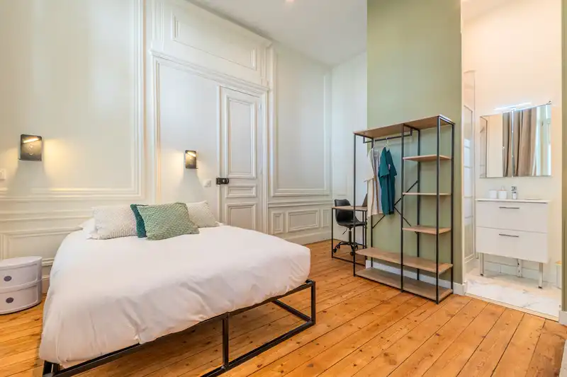Chambre avec lit double, penderie métal et salle d'eau, murs boisés — Maison Vauban, coliving IvyNest à Lille Vauban