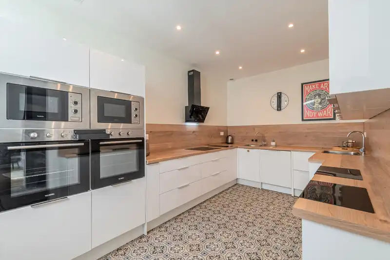 Cuisine équipée blanche avec fours encastrés et plan de travail en bois — Maison 67 Roland, coliving IvyNest à Lille Vauban