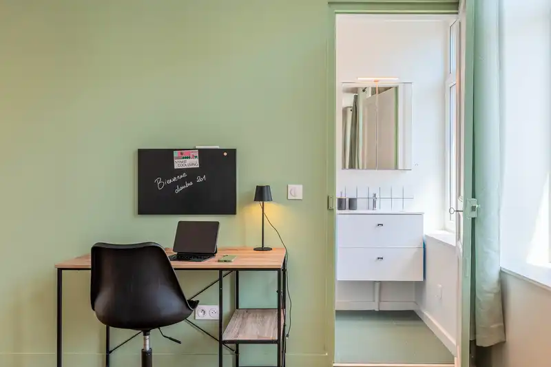 Chambre aux murs verts avec bureau, chaise noire et salle d'eau — Maison 68 Roland, coliving IvyNest à Lille Vauban