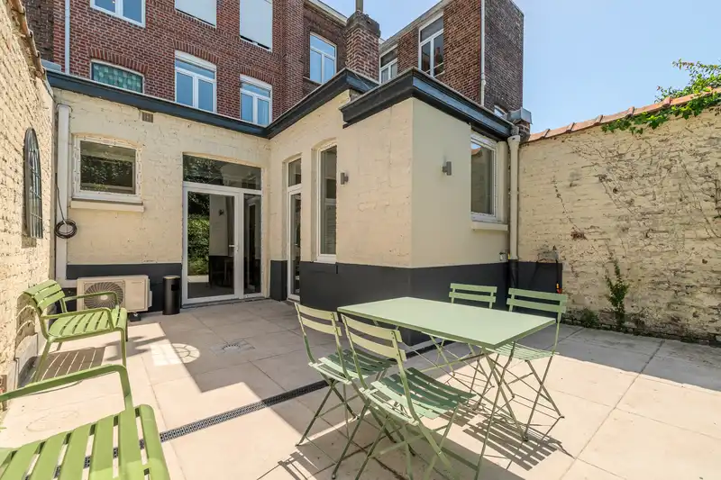 Cour arrière avec mobilier de jardin vert et façade jaune — Maison 68 Roland, coliving IvyNest à Lille Vauban