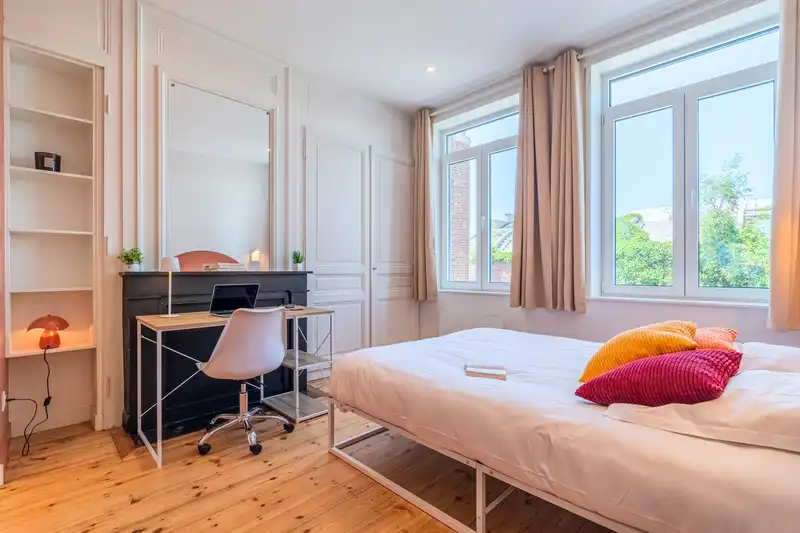 Chambre avec lit double, bureau, étagères et coussins rouges — Maison 68 Roland, coliving IvyNest à Lille Vauban