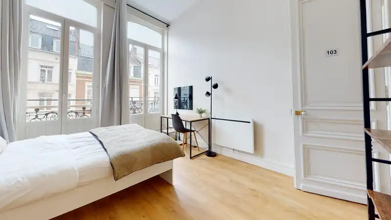 Chambre avec lit simple, bureau, téléviseur et porte numérotée — Maison 251 Solférino, coliving IvyNest à Lille République