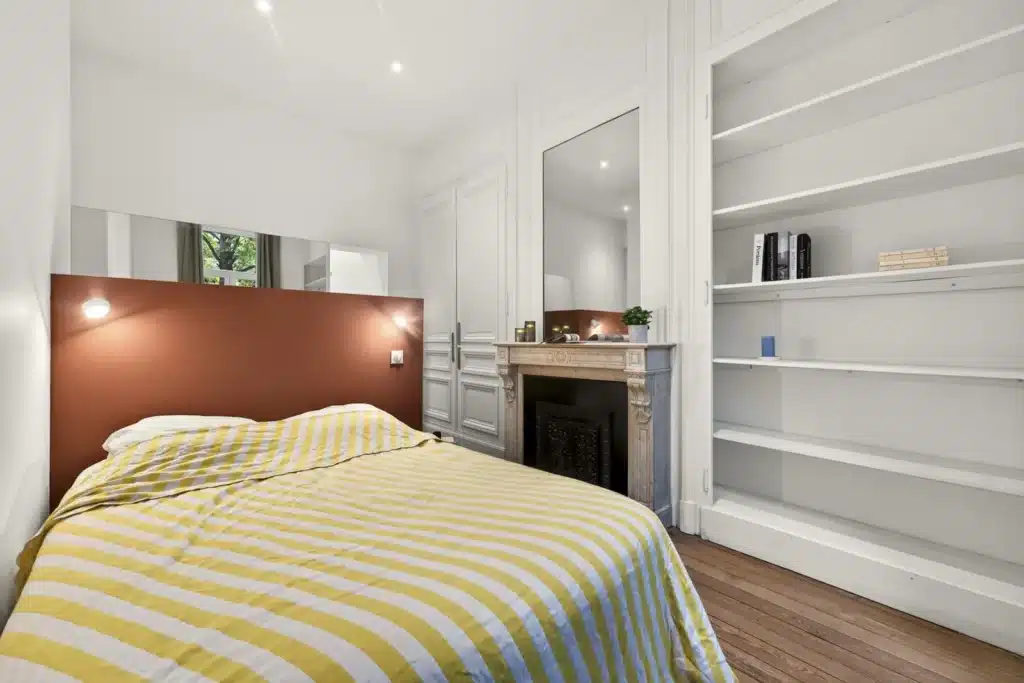 Chambre avec tête de lit terracotta et bibliothèque, coliving Lille