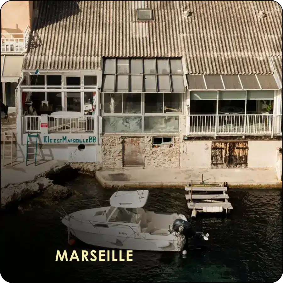 Coliving IvyNest à Marseille : maisons de pêcheurs et bateau au bord de la mer
