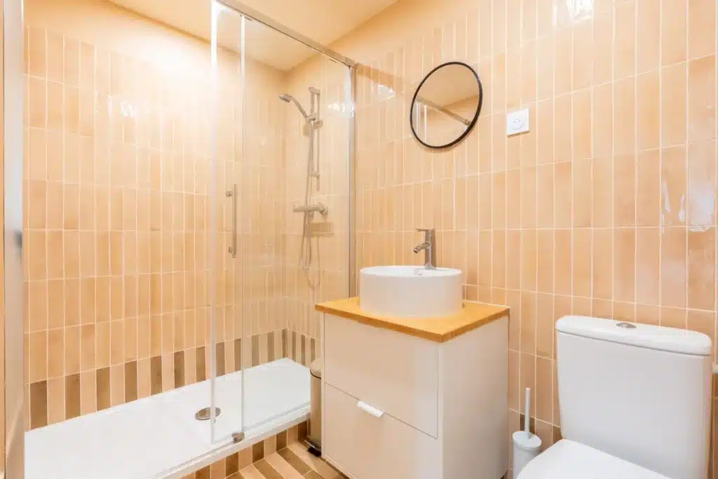 Salle de bain privative au carrelage terracotta, coliving Montreuil